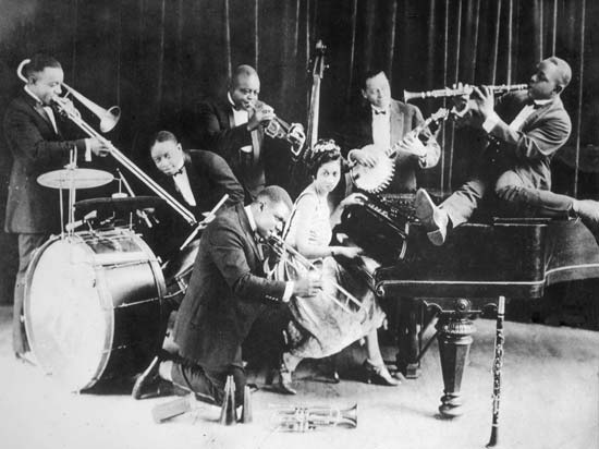 Joe "King" Oliver's Creole Jazz Band in Chicago, 1923. Honore Dutry (trombone), Baby Dodds (drums), Louis Armstrong (second cornet), King Oliver (cornet), Lil Hardin (piano), Bill Johnson (bass, banjo), and Johnny Dodds (clarinet).